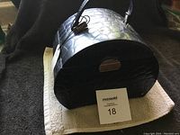 Closed black croc-embossed leather jewelry box with handle and metallic clasp, showing the Tuskan Designs tag.