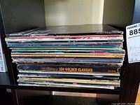 Side view of a stack of vintage vinyl LP albums showing various album spines including '150 Golden Classics'.