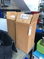 Two cardboard boxes labeled Genteq containing the capacitors.