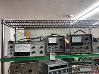 Wide view showing three electronic instruments on shelving: Bell 610 Gaussmeter on left, two HP transducer amplifiers on right.