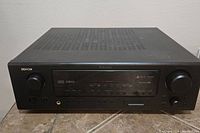 Front view of Denon AVR-587 showing overall unit including display, rotary knobs, input buttons and jacks.