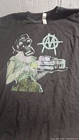 Front of the black Ministry Industrial Strength Tour shirt showing gas mask graphic and anarchy symbol