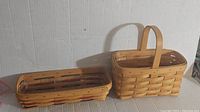 Pair of small Longaberger baskets, one with handle and one low tray style, both with inserts.