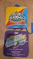 Pair of two vintage stadium seat cushions with event logos and graphics
