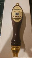 Front view of Yuengling Traditional Lager beer tap handle showing label, body and gold accents