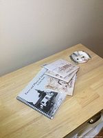 Overview of all items including book, three tiles, and ceramic dog dish on wooden table