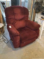 Front angle view of burgundy LaZBoy recliner rocker chair showing plush cushioning and padded armrests.