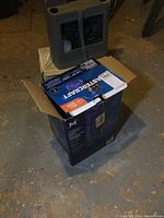 Boxed Mastercraft sump pump kit with hose on basement floor, box open indicating new condition.