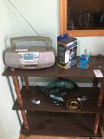 Sony boombox shows control panel and carrying handle on small wooden table.