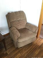 Front view of beige recliner rocker chair showing cushioned backrest, armrests, and seat.