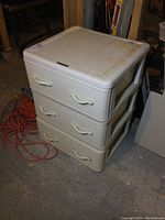 Front angled view of the white resin 3 drawer storage cabinet showing woven textured drawers and molded handles with some dirt and marks on surfaces.
