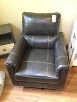 Frontal view showing the chair's padded armrests, seat, and backrest with white contrast stitching.