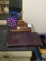 Overview photo showing the vintage Scrabble box, purple Las Vegas clock, wooden valet organizer with men's jewelry on top.