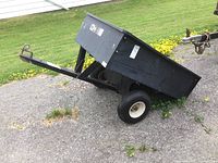 Three-quarter front view of Agri-Fab dump cart on gravel showing overall configuration