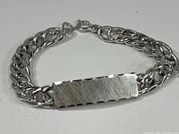 Full view of the sterling silver bracelet showing the double chain and flat plate