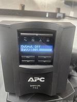 Front view of APC Smart-UPS 750 showing LCD screen with battery status and control buttons.