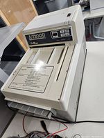 Full view of machine showing feed tray, control panel, and power switch.