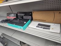 Photo shows multiple keyboard boxes and a wrapped keyboard on a store shelf.