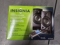 Box and front view of Insignia stereo computer speakers NS-PCS40 packaging showing product image and branding.