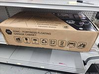 Photo of the closed boxed Manhattan Comfort Fortress Floating Garage Cabinet showing model and key features on the box.