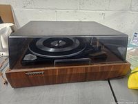 Front view of the Panasonic turntable showing wood grain base and clear dust cover.