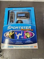 Front of the seller's box showing Sirius Sportster Replay satellite radio system with receiver and remote, highlighting features like pausing radio, music channels, sports, and talk.