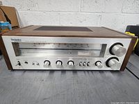 Front view of the Technics stereo receiver showing control knobs and wooden sides.