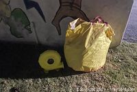 Photo of yellow blower and deflated bounce castle packed in yellow bag.