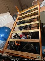 Photo of brown wooden twin size bed frame lying on its side showing slats and frame structure.