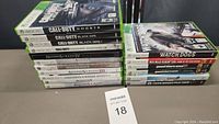 View of 17 Xbox 360 game cases stacked showing spines and titles