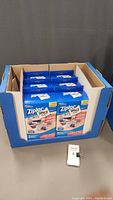 Photo of six Ziploc Space Bag packages in a blue cardboard display box, showing front of the boxes