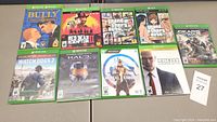 Overview of nine Xbox One game cases laid out on a table showing front cover art.