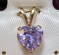 Close-up photo of the heart-shaped cubic zirconia pendant set in 10K gold with V-shaped bale inside a jewelry box.