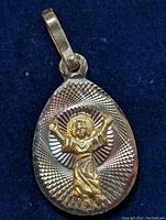 Front view of the 10K yellow gold religious pendant featuring Jesus Christ figure with detailed radial textured background and bail for chain attachment.