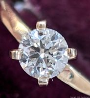 Close-up of round diamond in four-prong setting on yellow gold band