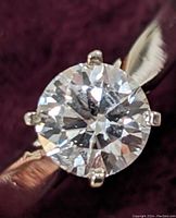 Close-up of round brilliant cut diamond in six-prong setting