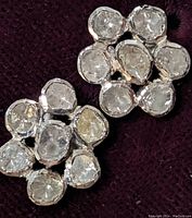 Close-up photo of two earrings featuring clusters of natural rough diamond chips set in stainless steel.