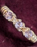 Close-up photo of the sterling silver ring showing three round amethyst stones set horizontally on the band.