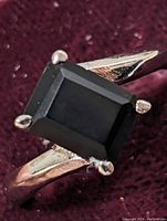 Close-up photo showing the rectangular faceted black onyx stone on a sterling silver ring band.