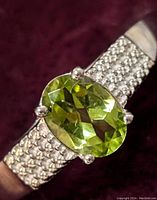 Close-up image of the sterling silver ring showing the 0.80ct faceted oval peridot gemstone set with four prongs.