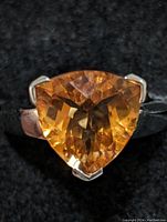 Close-up front view of the ring showing the triangular yellow quartz gemstone set in sterling silver.