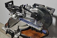 Front side view of Kobalt 12-inch compound sliding miter saw showing blade, base, and control knobs.