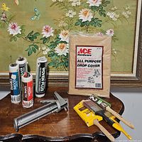 Photo showing all items on a wooden table including roller covers, drop cover, caulk holder, paint brushes.