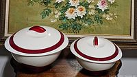 Pair of two vintage round plastic storage bowls with lids, white with red bands and handles.
