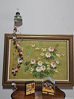 Full view of the lot including the hand painted clay wind chime hanging on the wall, Asian style wood jewelry box on table, and vintage clown trapeze music box by Koji Murai.