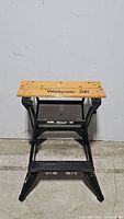 Full view of Black & Decker Workmate 200 portable work center showing wooden top with logo and metal frame in used condition.