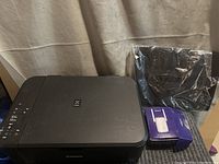 Canon PIXMA black printer, black notebook, and Kingston USB flash drive box shown together