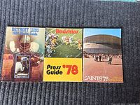 Three NFL media press guides, Detroit Lions 1980, Redskins 1978, Saints 1978 placed side by side on carpet