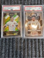 Front view of two PSA graded soccer cards featuring Robert Lewandowski and Leroy Sane visible through their slabs showing the player's image and card details.