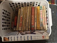 Photo showing the row of vintage sports books in a white basket with worn aged paperback covers.